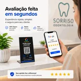 Cliente avaliando no Google pelo celular ao lado da Placa de Balcão M numa recepção: "Avaliação feita em segundos — 100% seguro, sem dados pessoais; rápido; fácil, qualquer pessoa usa"